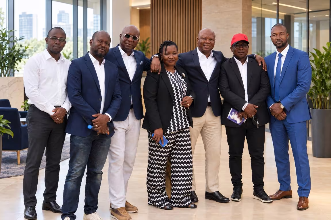 Seven members of the Scham’s Consulting team standing side by side in a bright hall